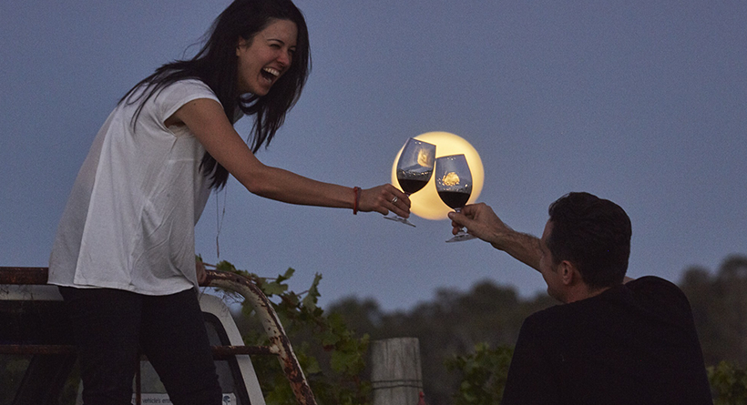 Two people celebrating with two glasses of Cullen wine under a full moon